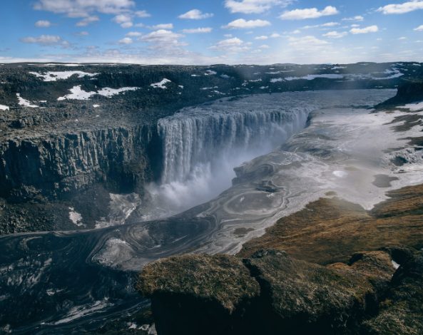 Dettifoss seen from above, the falls dropping the full width of the canyon with the braided glacial river below
